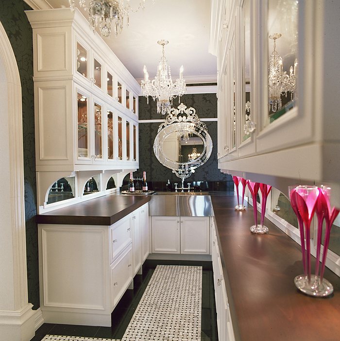 Butler's pantry with mirrored cabinetry and a walnut counter