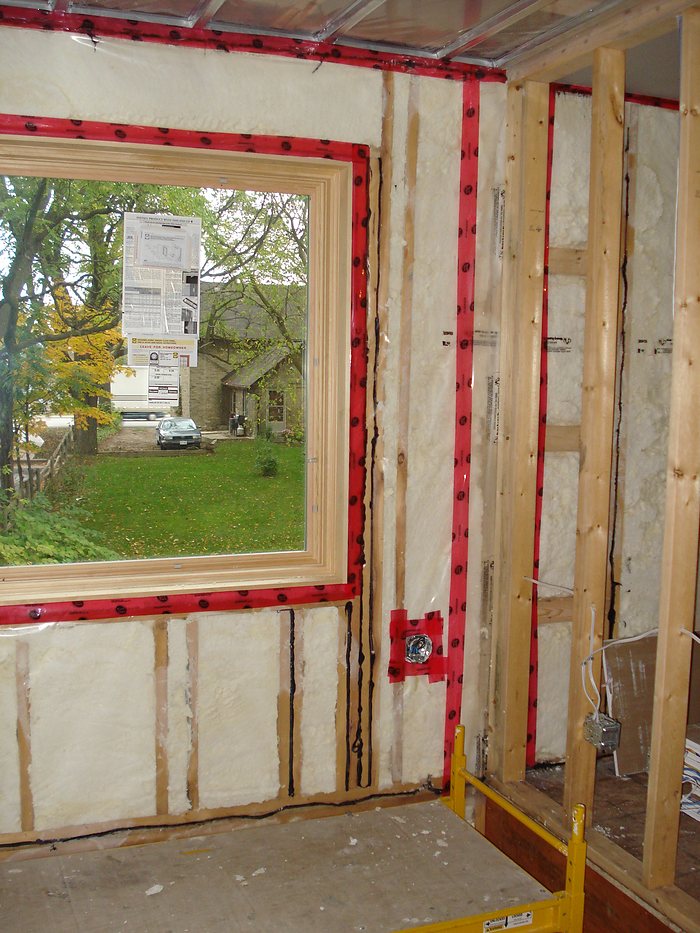 Spray foam insulation applied around a framed window opening