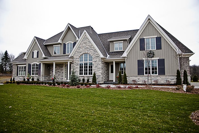 Completed custom home exterior in stone and board-and-batten siding