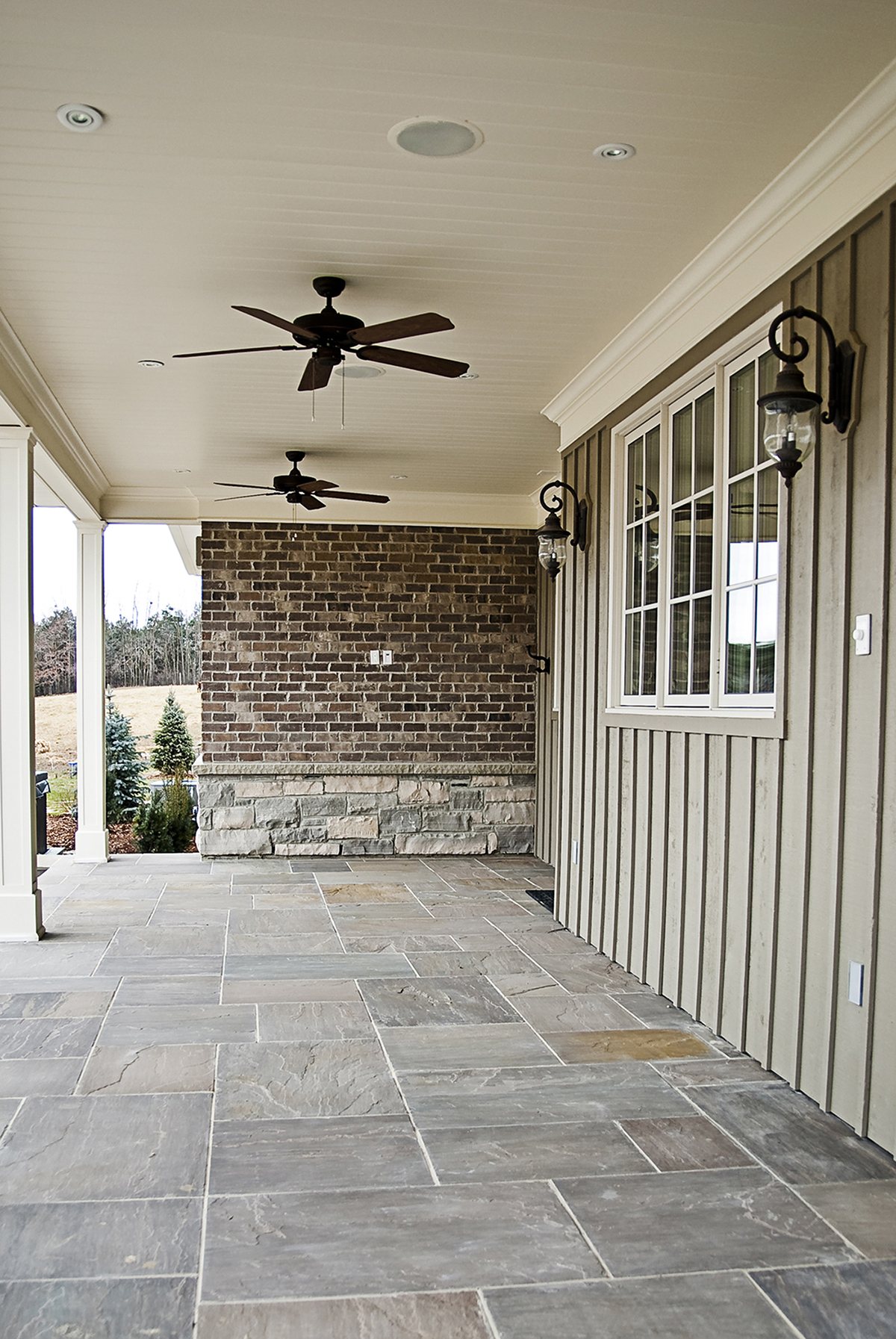 Covered porch with a flagstone floor, stone piers and board-and-batten walls