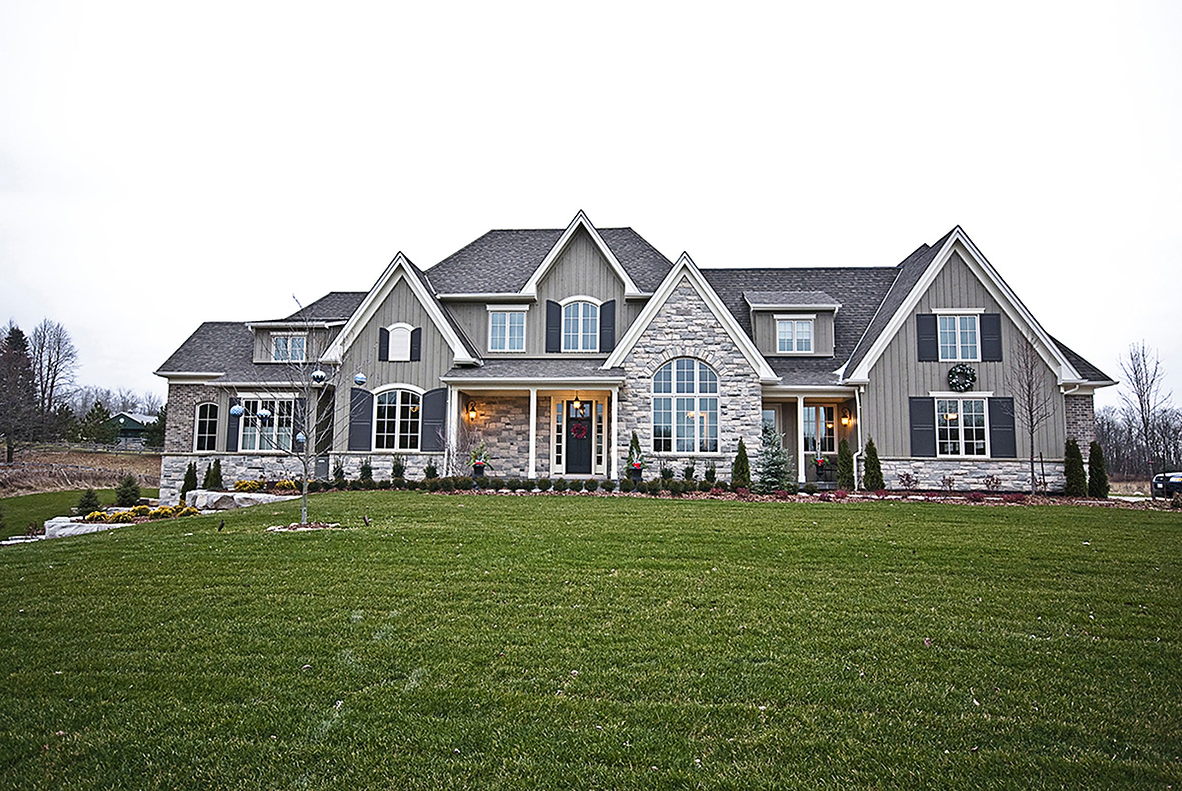 A completed Birkshire custom home in cut stone and board-and-batten siding